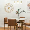 A dining area with a large gold clock on a white shiplap wall, a marble-top dining table with brown chairs, and a vase of flowers. Voir les images du produit