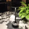 A black LED table lamp sits on a marble-patterned table next to a potted plant. Produktbild-Vorschau