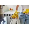 A person wearing yellow gloves is cleaning a kitchen counter with a cloth and spray bottle. Produktbild-Vorschau