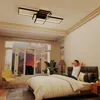 A man is relaxing on a bed in a bedroom, with a modern ceiling light fixture visible. Voir les images du produit