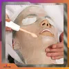 A person receiving a facial treatment with a device. Produktbild-Vorschau