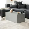 A modern living room scene with a grey sectional sofa and a grey rectangular coffee table. Produktbild-Vorschau