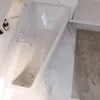 A modern bathroom with a white bathtub and marble accents. Produktbild-Vorschau