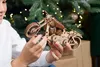 A person is holding a wooden model motorcycle in front of a Christmas tree. Anteprima dell’immagine prodotto