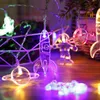 A string of decorative LED lights shaped like rockets, planets, and astronauts, illuminated with colorful lights, displayed in a room setting. Náhled obrázku produktu