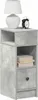A tall, narrow nightstand with a concrete-like finish, featuring an open shelf, a drawer, and a small shelf above the drawer. A white lamp and a black alarm clock are placed on the top surface. Voir les images du produit