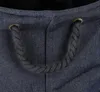 A close-up view of the top opening of a dark blue fabric basket with a black rope handle threaded through two gold grommets. Podgląd zdjęcia produktu
