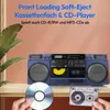 A blue boombox with a CD player and cassette deck is displayed on a shelf, with a CD and cassette tape in the foreground. Podgląd zdjęcia produktu