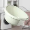 A cream-colored plastic bowl is shown in a laundry room setting, with a washing machine and drying rack blurred in the background. Produktbild-Vorschau