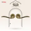 A pair of antique bronze door handles are displayed against a stylized archway and a patterned background. Produktbild-Vorschau