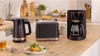 A kitchen counter with a toaster, coffee maker, and kettle. Voir les images du produit