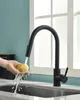 A hand is washing a lemon under a black kitchen faucet. Produktbild-Vorschau