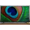A television displaying a peacock feather image, placed on a wooden table. Produktbild-Vorschau