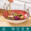 A hand holding a fork is about to take food from a bowl of salad. Náhled obrázku produktu