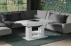 A white coffee table is placed in front of a sectional sofa in a living room setting. Voir les images du produit