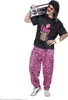 A man dressed in an 80s-themed costume, complete with a wig, sunglasses, a t-shirt with a graphic, and patterned pants, carrying a boombox. Produktbild-Vorschau