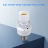 A white E27 motion sensor lamp holder is placed on a blue surface against a light blue background. Podgląd zdjęcia produktu