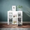 A white sideboard with glass doors and shelves, decorated with books, bottles, and decorative items, stands against a textured blue wall. Anteprima dell’immagine prodotto
