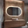 A modern bathroom vanity with a sink and an illuminated oval mirror. Produktbild-Vorschau