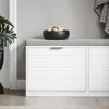 A close-up view of a white shoe cabinet with a gray upholstered seat and a black decorative bowl on top. Anteprima dell’immagine prodotto