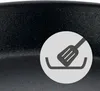 A close-up of a dark, speckled pan surface with a circular graphic overlay showing a spatula in a pan. Produktbild-Vorschau