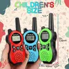 Three children's walkie-talkies in red, blue, and green are held in a hand against a patterned background. Voir les images du produit