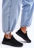 A person wearing light blue jeans and black slip-on sneakers. Náhľad obrázku produktu