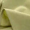 A close-up view of a light green fabric, showing the texture and stitching. Produktbild-Vorschau