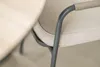 A close-up of a chair armrest and seat cushion next to a table. Produktbild-Vorschau