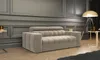 A beige sofa is placed in a modern living room with paneled walls and wooden flooring. Produktbild-Vorschau