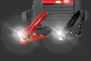 A close-up shot of a car power pack with red and black jumper cable clamps illuminated by bright lights. Anteprima dell’immagine prodotto