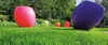 Several colorful, modern-looking planters are arranged on a lush green lawn in a garden setting. Voir les images du produit