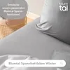 A close-up of a gray bed sheet with a pillow, suggesting comfort and warmth. Produktbild-Vorschau