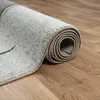 A rolled-up rug on a wooden floor. Produktbild-Vorschau