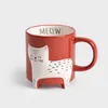 A red mug with a white cat design on it, set against a plain white background. Produktbild-Vorschau