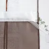 A close-up view of a sheer curtain with text printed on it, showing the top hem and a decorative ribbon. Produktbild-Vorschau