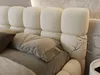 A close-up view of a beige upholstered bed with a textured headboard and bedding. Produktbild-Vorschau