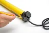 A hand is shown adjusting a yellow tubular motor with a yellow tool. Produktbild-Vorschau