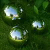 Three polished stainless steel garden spheres are placed on green grass, reflecting the surrounding environment. Produktbild-Vorschau