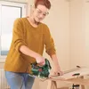 A woman is using a jigsaw to cut a piece of wood. Náhled obrázku produktu