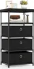 A black fabric storage unit with three drawers and a wooden top shelf, decorated with a few items. Náhled obrázku produktu