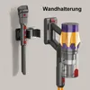 Two parts of a cordless vacuum cleaner are shown mounted on a wall holder. Náhled obrázku produktu