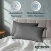 A bed with two gray pillowcases on top of white bedding, with marketing text and icons in the background. Produktbild-Vorschau