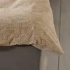A close-up view of a beige duvet cover with a textured pattern, resting on a grey bed base. Produktbild-Vorschau