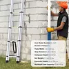 A man in safety gear is holding a white pipe next to a silver telescopic ladder leaning against a brick wall. Náhľad obrázku produktu