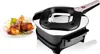 A close-up shot of an electric roaster next to a plate of cooked chicken legs. Anteprima dell’immagine prodotto
