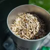A close-up view of wood chips in a metal container. Produktbild-Vorschau
