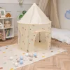 A children's play tent is set up on a rug in a room with a bed and a bookshelf. Náhled obrázku produktu