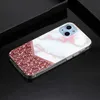 A close-up shot of a phone case with a marble and glitter design, placed on a dark surface. Produktbild-Vorschau
