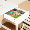A close-up view of an open drawer in a white desk, containing children's books and toy animals. Podgląd zdjęcia produktu